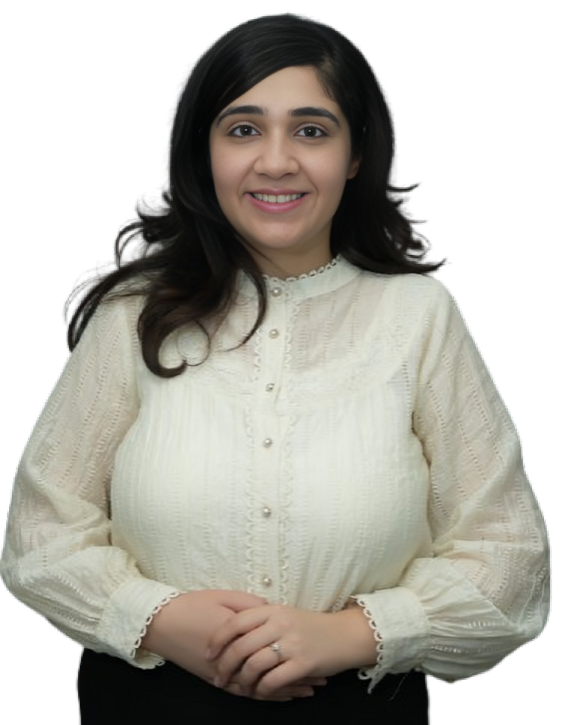 Portrait of Dr. Sonal Hemnani, a smiling woman with long dark hair, wearing a cream-colored, long-sleeved blouse with delicate lace details. She is standing with her hands gently clasped in front of her
