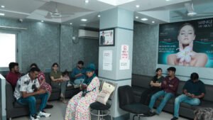 Waiting room inside Dr. Hemnani’s Cosmoderm clinic with several people seated on sofas and chairs, some looking at their phones, others chatting or sitting quietly.